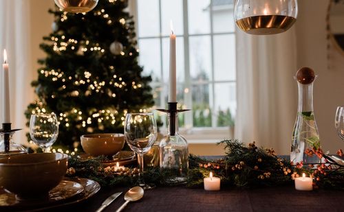 Tall candle on a festively decorated dinner table at christmas