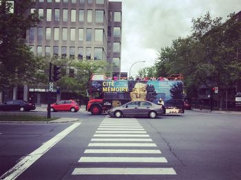 Cars on road in city against sky