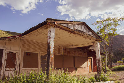 Old abandoned house on field against sky