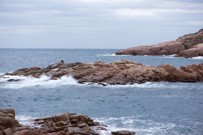 Scenic view of sea and rocks against sky