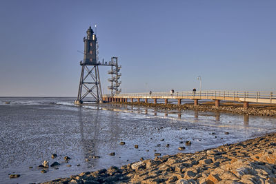 Bridge over sea against clear sky