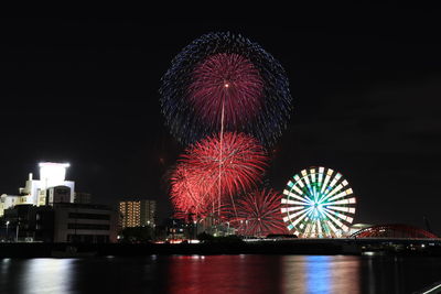 Firework display over river at night
