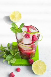 Pink cocktail or lemonade with raspberries, mint, lime and ice. summer refreshment drink.