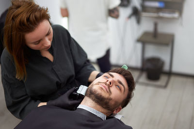 Close-up of man sitting in barber shop