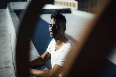 Midsection of man sitting in sunlight