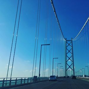 View of suspension bridge against blue sky