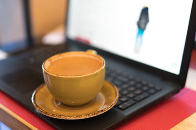 Close-up of coffee cup on laptop
