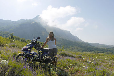 People riding bicycle on field against sky