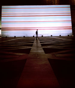 Blurred man walking on pathway against the wall