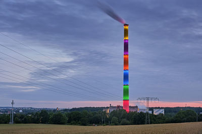 Wind turbines on field against sky