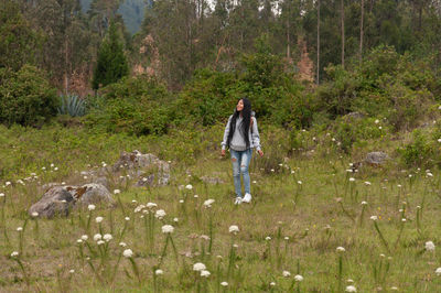 Rear view of woman walking on field