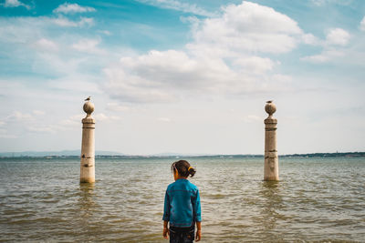 Rear view of woman looking at sea against sky