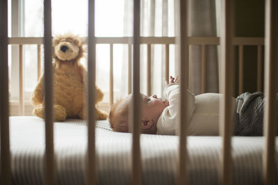 Side view of baby boy lying in crib