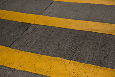 High angle view of yellow arrow symbol on road