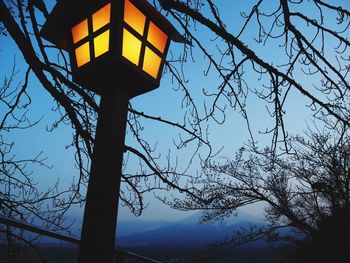 Low angle view of illuminated street light against sky