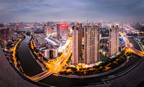 Fish-eye lens view of illuminated cityscape at dusk