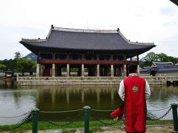 Rear view of man standing against building