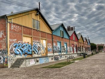 Graffiti on wall in city against sky