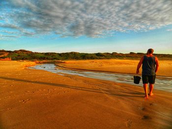 Rear view of man walking on beach