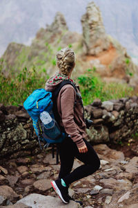 Rear view of woman standing on rock