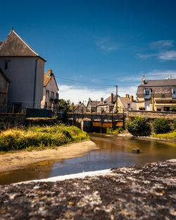 River amidst buildings against blue sky