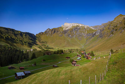 Scenic view of landscape and mountains against blue sky