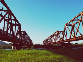 Low angle view of bridge against clear blue sky