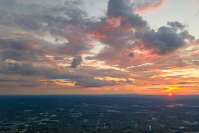 Aerial view of cityscape against dramatic sky during sunset