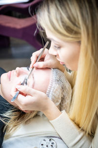 High angle view of woman applying medical eye patch