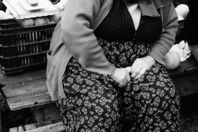 Midsection of woman sitting on seat