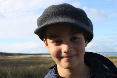 Portrait of teenage boy wearing cap against sky