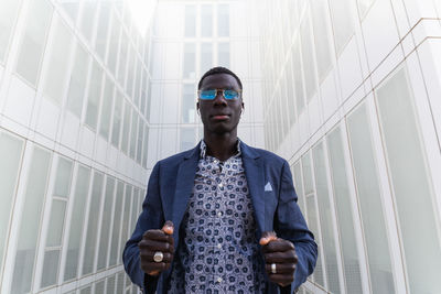 Portrait of young man standing against wall