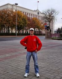 Portrait of man standing on footpath in city