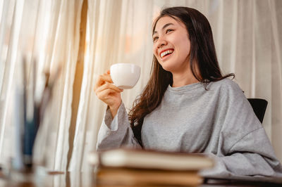 Smiling businesswoman holding cup