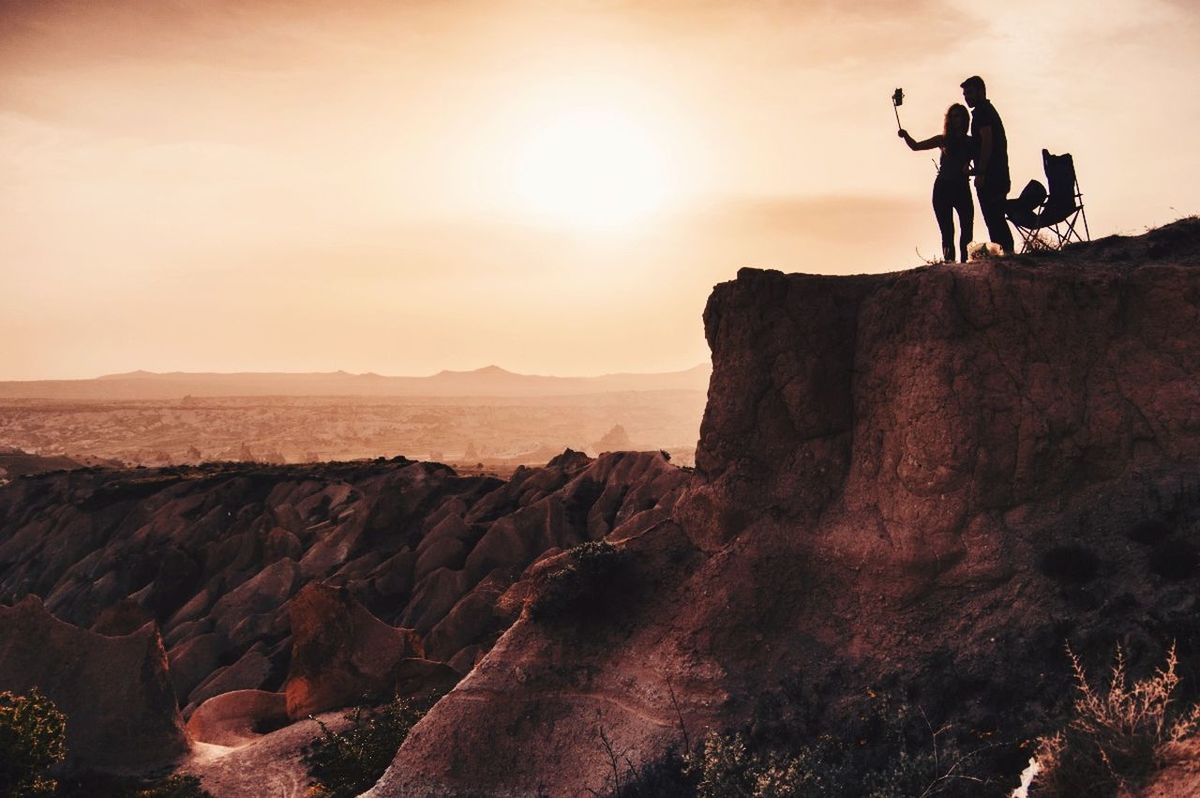 rock - object, sunset, two people, rock formation, cliff, nature, silhouette, real people, outdoors, landscape, adventure, togetherness, leisure activity, beauty in nature, scenics, travel destinations, lifestyles, tranquility, men, women, rock climbing, sky, mountain, day, adult, people