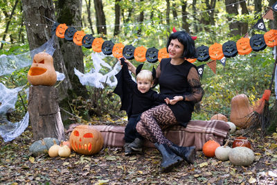 Halloween. mother with little son in halloween costumes having fun outdoor