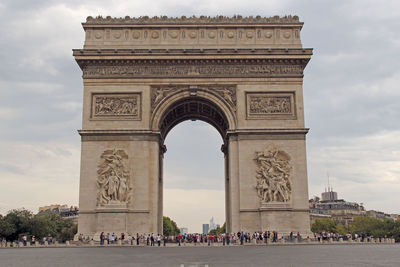 People in front of arc de triomphe against sky