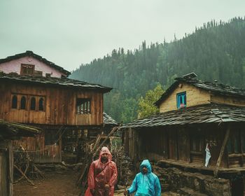 People outside house against sky