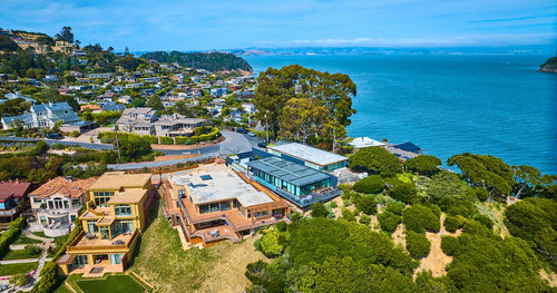 High angle view of townscape by sea against sky