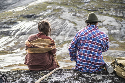 Rear view of couple standing on rock