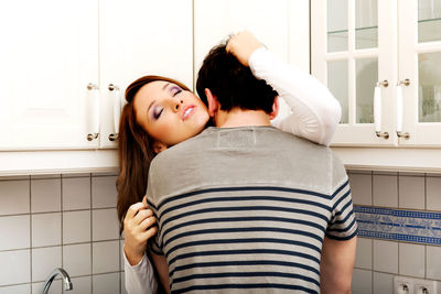 Rear view of woman with friends at home