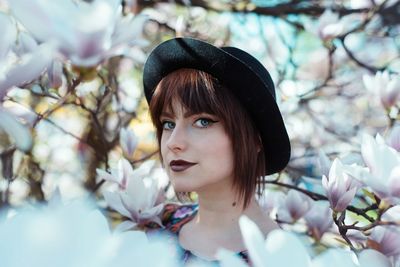 Portrait of young woman amidst cherry blossoms