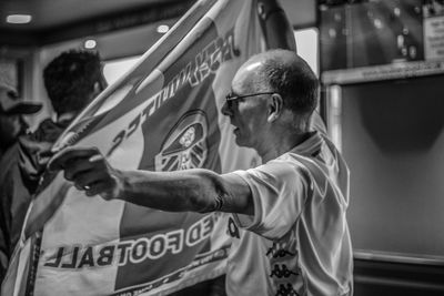 Side view of man looking at camera