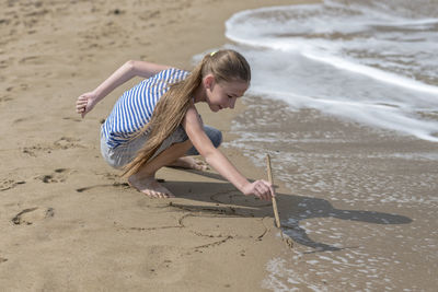 Girl playing on sand at beach
