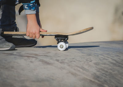 Low section of man with skateboard at park