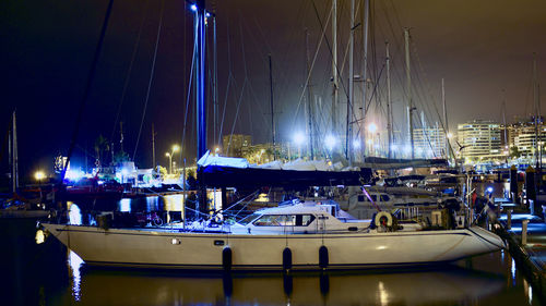 Boats moored in harbor at night