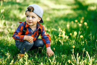 Cute boy sitting on field