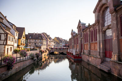 Bridge over canal amidst buildings against sky