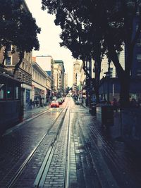 Railroad tracks in city against sky