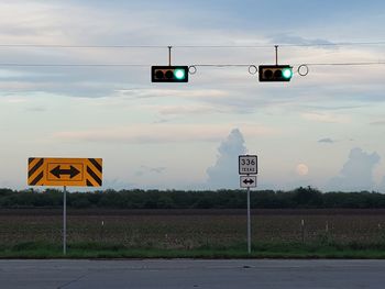 Information sign on road against sky